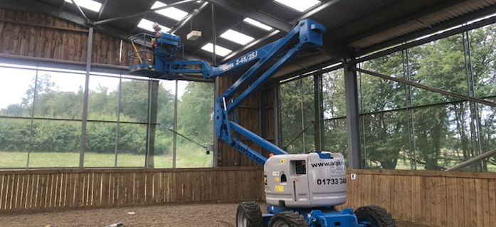 A cherry picker being used to carry out skylight cleaning in a warehouse